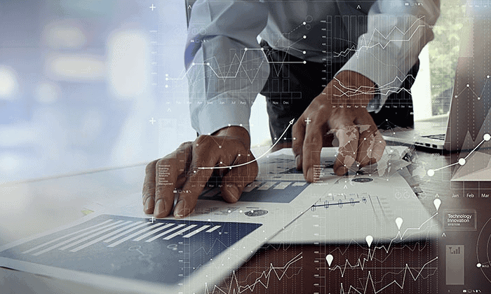 Geschäftsmann analysiert Finanzdaten und Förderquellen am Laptop.