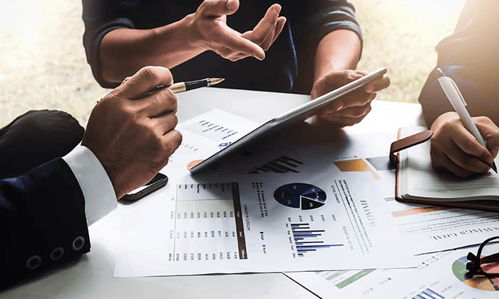 Geschäftsleute analysieren Finanzberichte zur Senkung der SSI-Kosten.